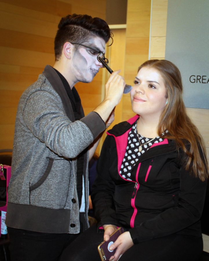 Xavier Todd, undecided major, applies Halloween makeup to Monica Renteria, nursing major. 