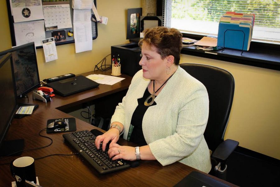 Kris Falzone, associate vice chancellor for Marketing and Communications, works at her desk. 