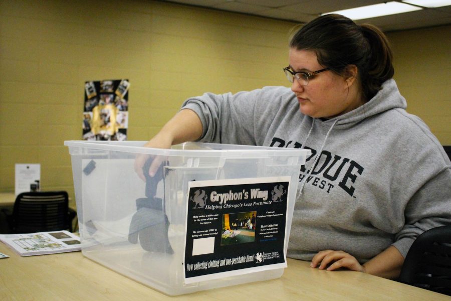 Kathryn Baum, junior communications major, places an item in the donation bin. 