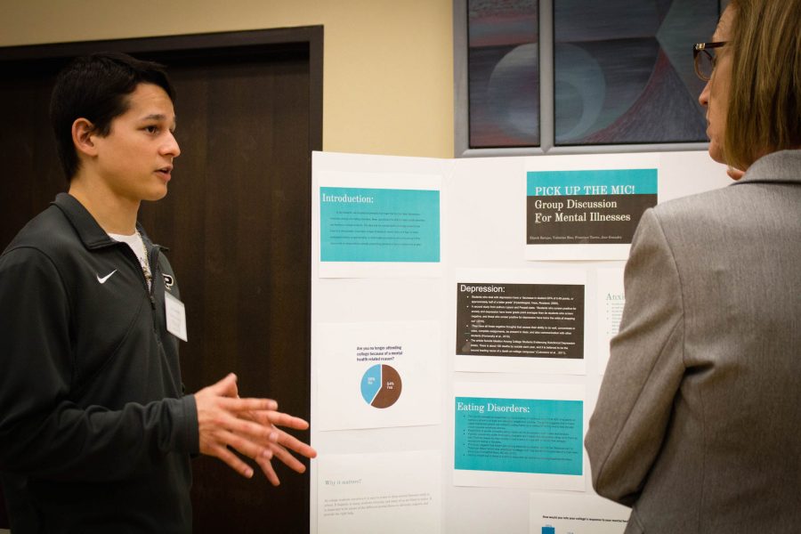 Jose Gonzalez,
freshman construction
management and accounting major (left), speaks about his presentation during Student Research Day.