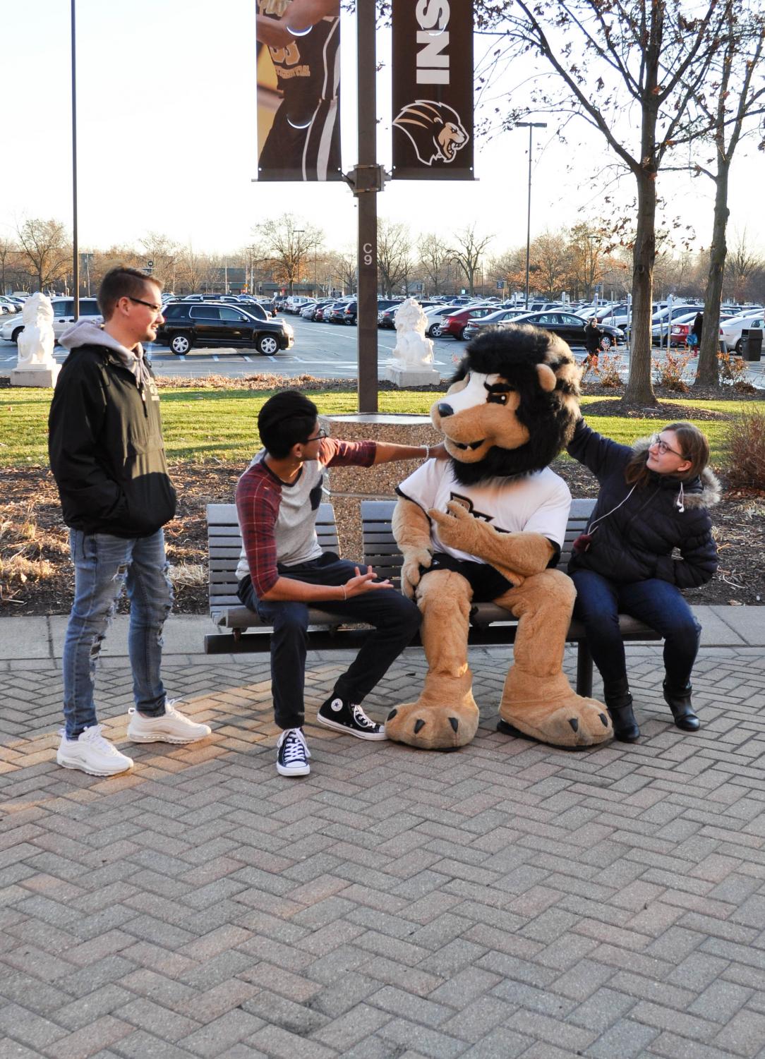 Matthew Kiel (left), freshman engineering major, Ruben Gonzalez (left center), freshman
criminal justice major, and Kalina Ziemlo (right), freshman elementary education major hang
out with Leo.