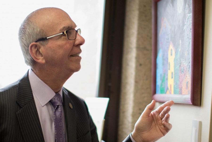 Chancellor Thomas Keon points to one of his paintings in Vice Chancellor for Institutional Advancement Regina Biddings-Muro’s
office.