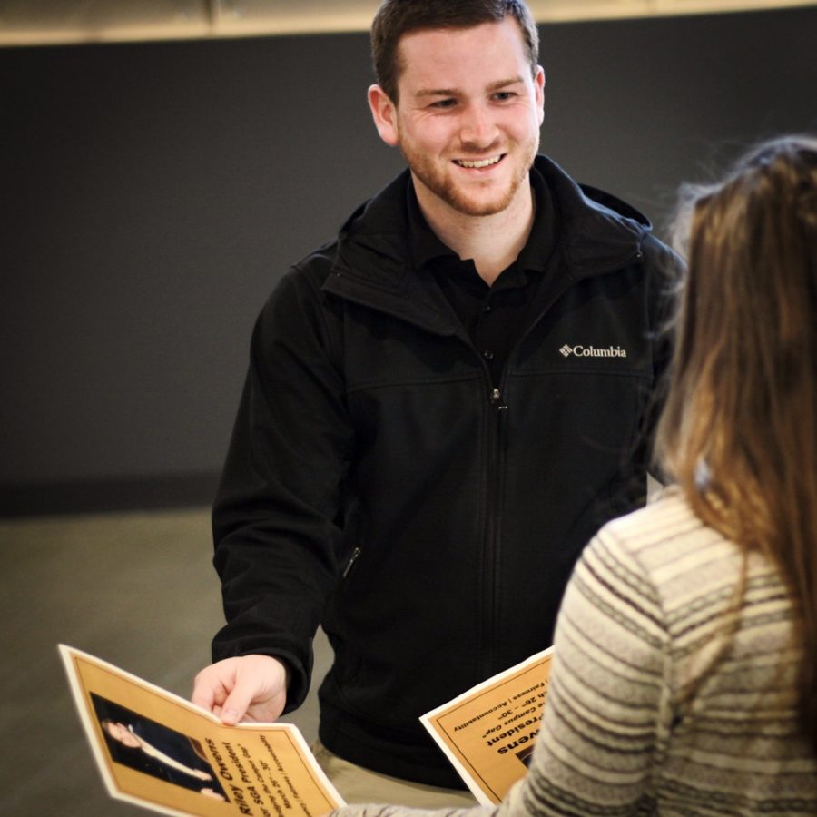 Riley Owens talks to PNW students while passing out his campaign flyers for the SGA presidential race.